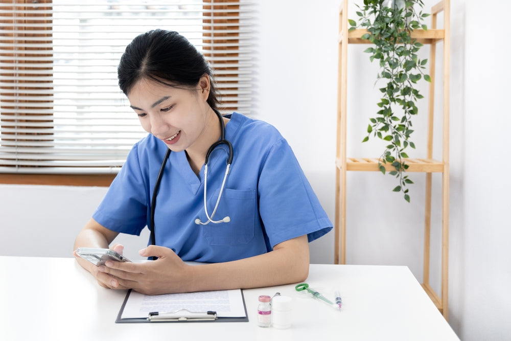 A veterinarian types a message on a phone